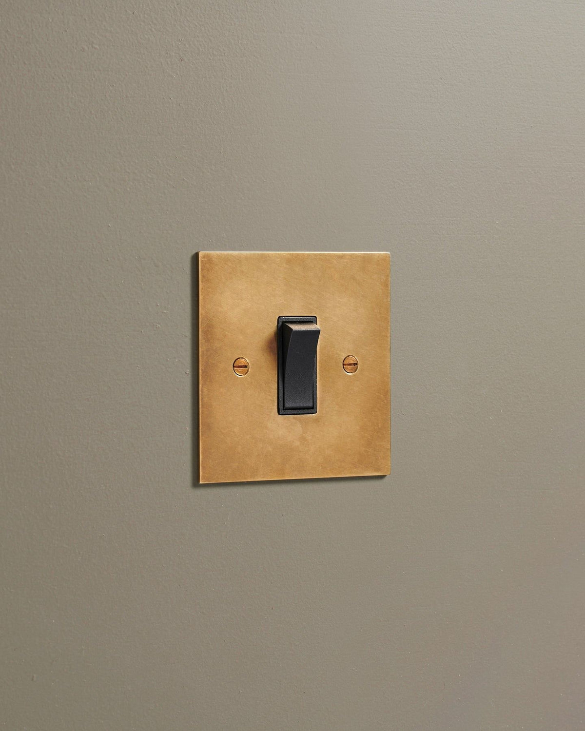 An oblique view of a classic 20 amp switch in a warm burnished brass finish. TEST