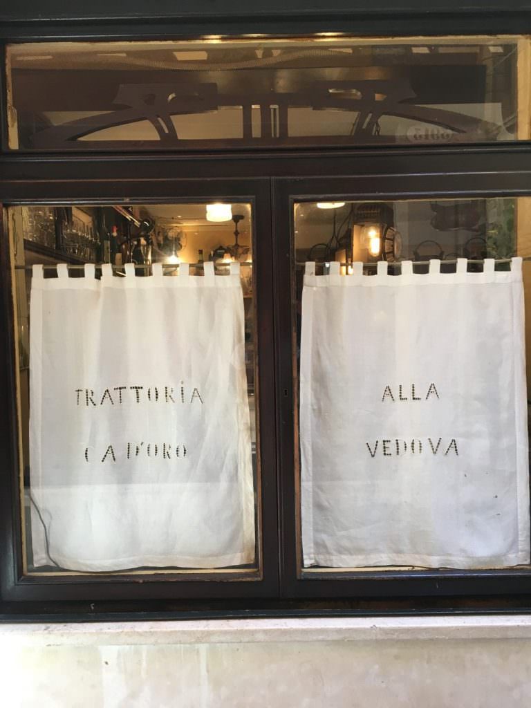 A typical Bacari window, starched white panels of embrioded cotton bearing the name.