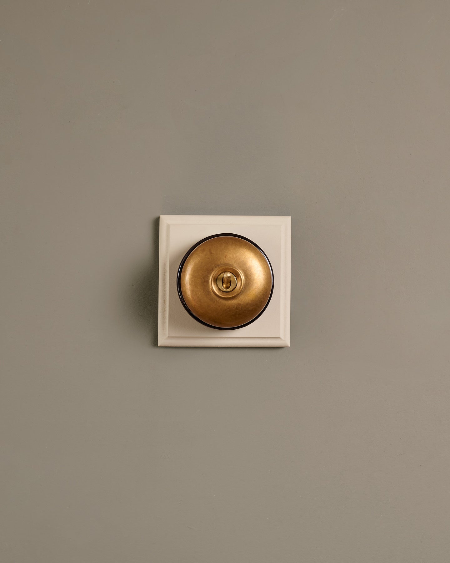 The Dolly Toggle Switch (1 Gang & Primed Maple Pattress) - Aged Brass with Black Base.
