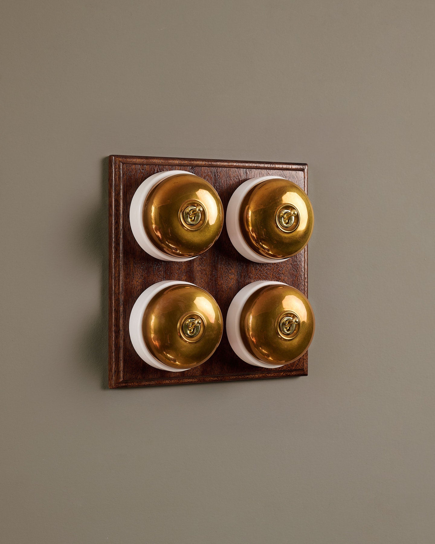 The Dolly Toggle Switch (4 Gang Bank & Mahogany Finish Pattress) - Heirloom Brass with White Base.