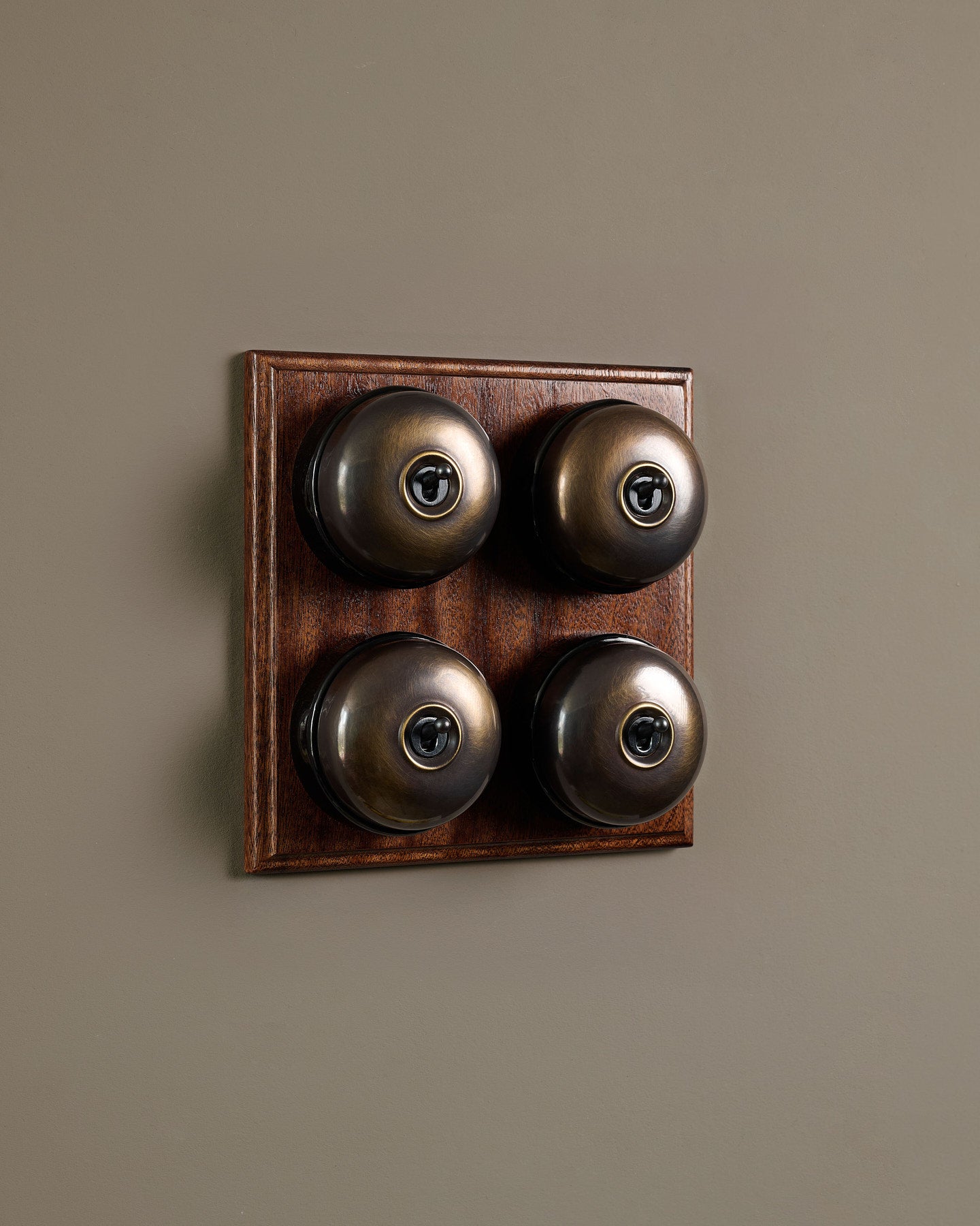 The Dolly Toggle Switch (4 Gang Bank & Mahogany Finish Pattress) - Oxidised Brass with Black Base.