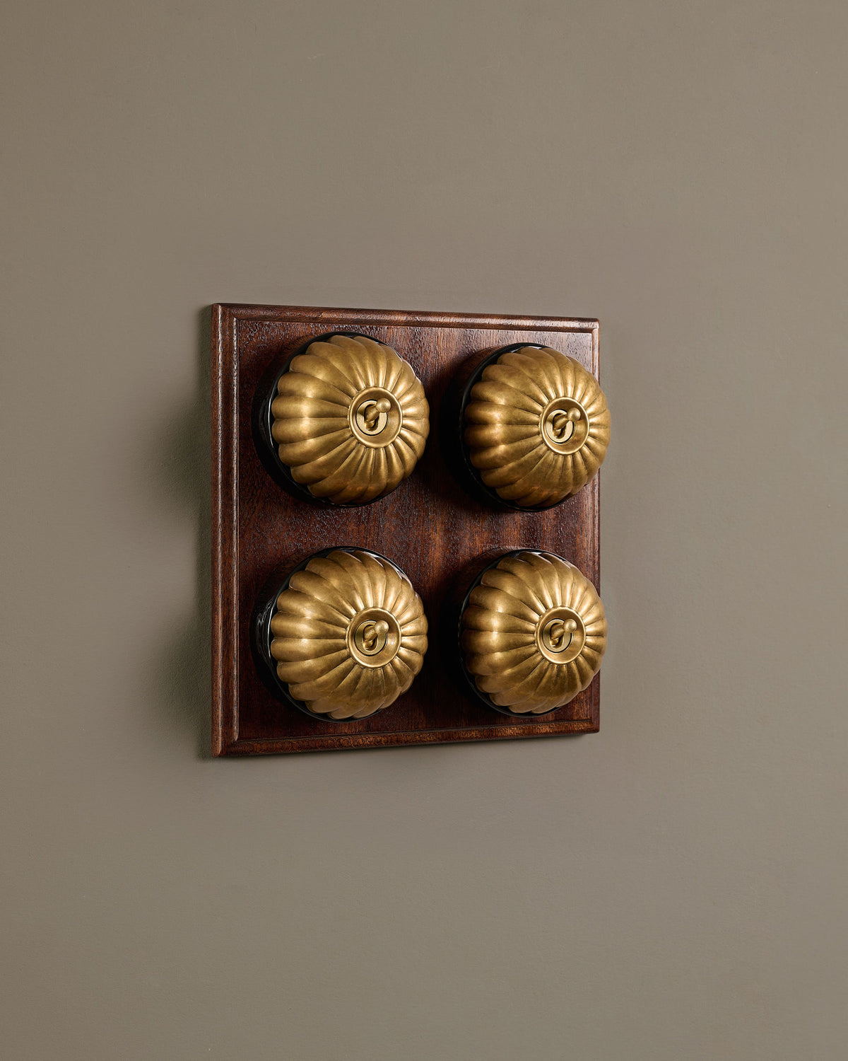 The Jelly Toggle Switch (4 Gang Bank & Mahogany Finish Pattress) - Aged Brass with Black Base. TEST