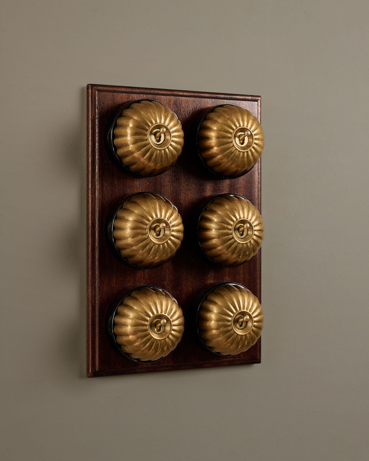 The Jelly Toggle Switch (6 Gang & Mahogany Finish Pattress) - Aged Brass with Black Base. TEST