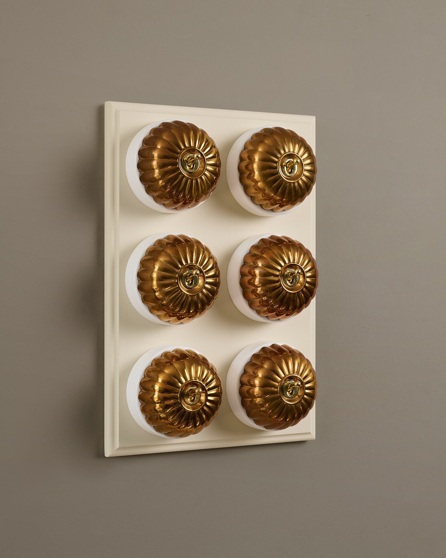 The Jelly Toggle Switch (6 Gang & Primed Maple Pattress) - Heirloom Brass with White Base.