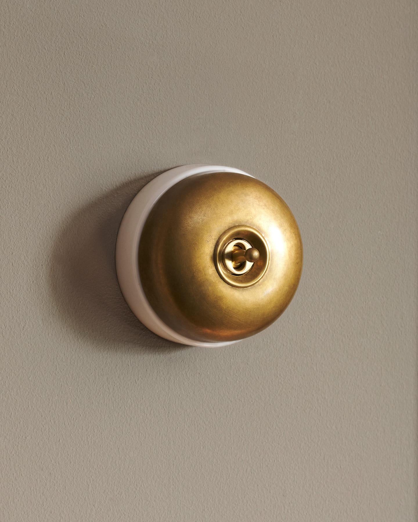 The Dolly Toggle Switch - Aged Brass, White Base, Retract to Centre