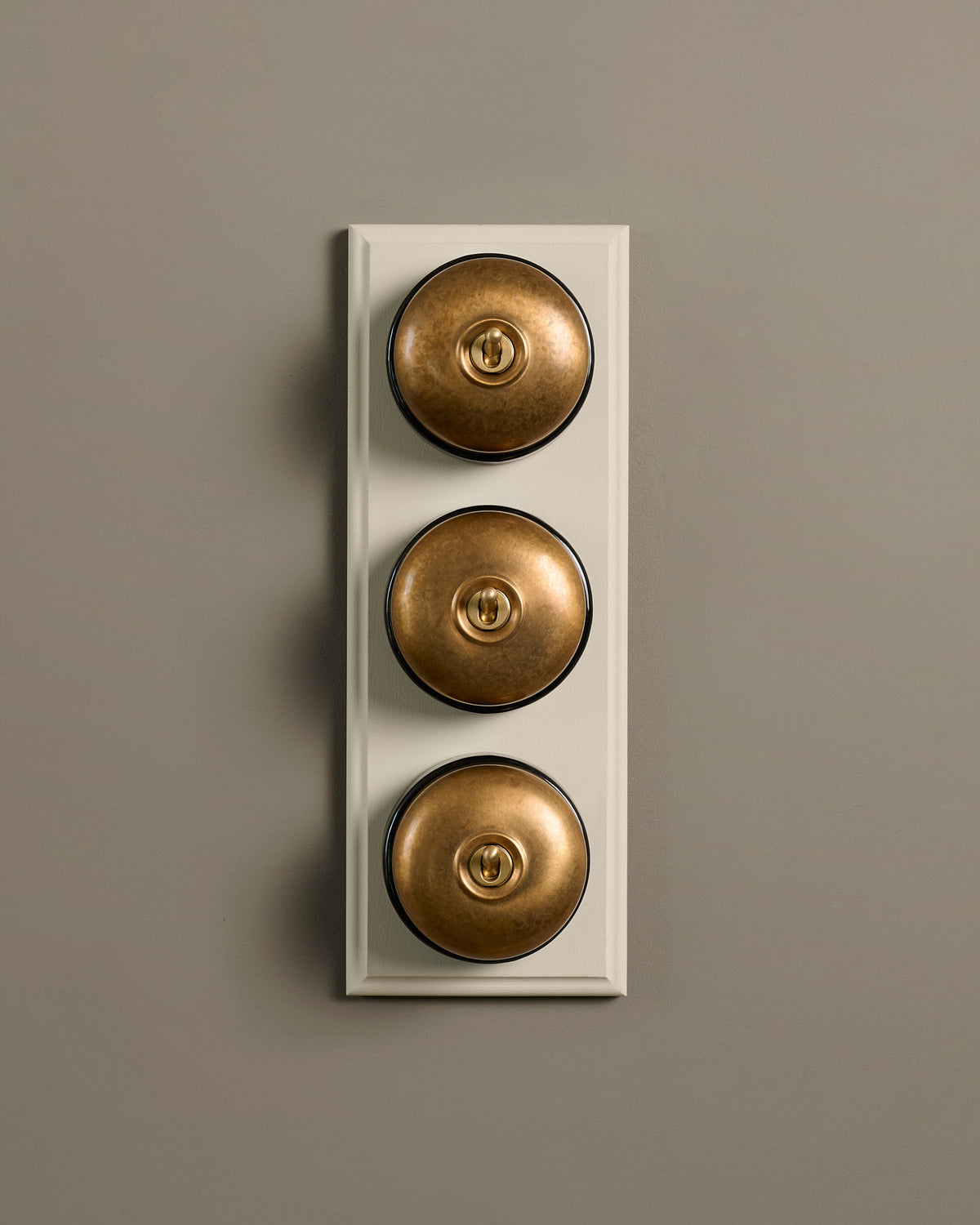 The Dolly Toggle Switch (3 Gang & Primed Maple Pattress) - Aged Brass with Black Base. TEST