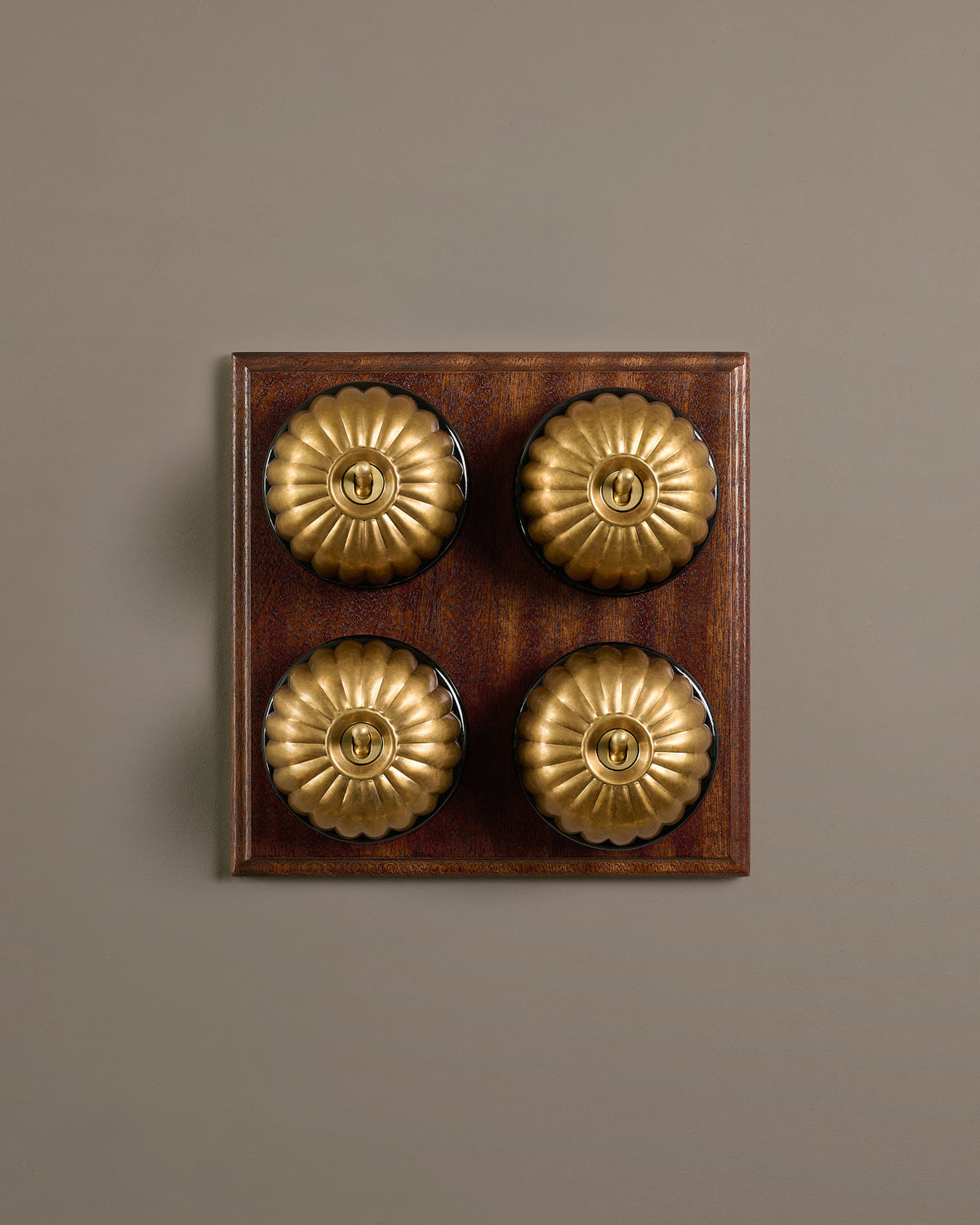The Jelly Toggle Switch (4 Gang Bank & Mahogany Finish Pattress) - Aged Brass with Black Base. TEST