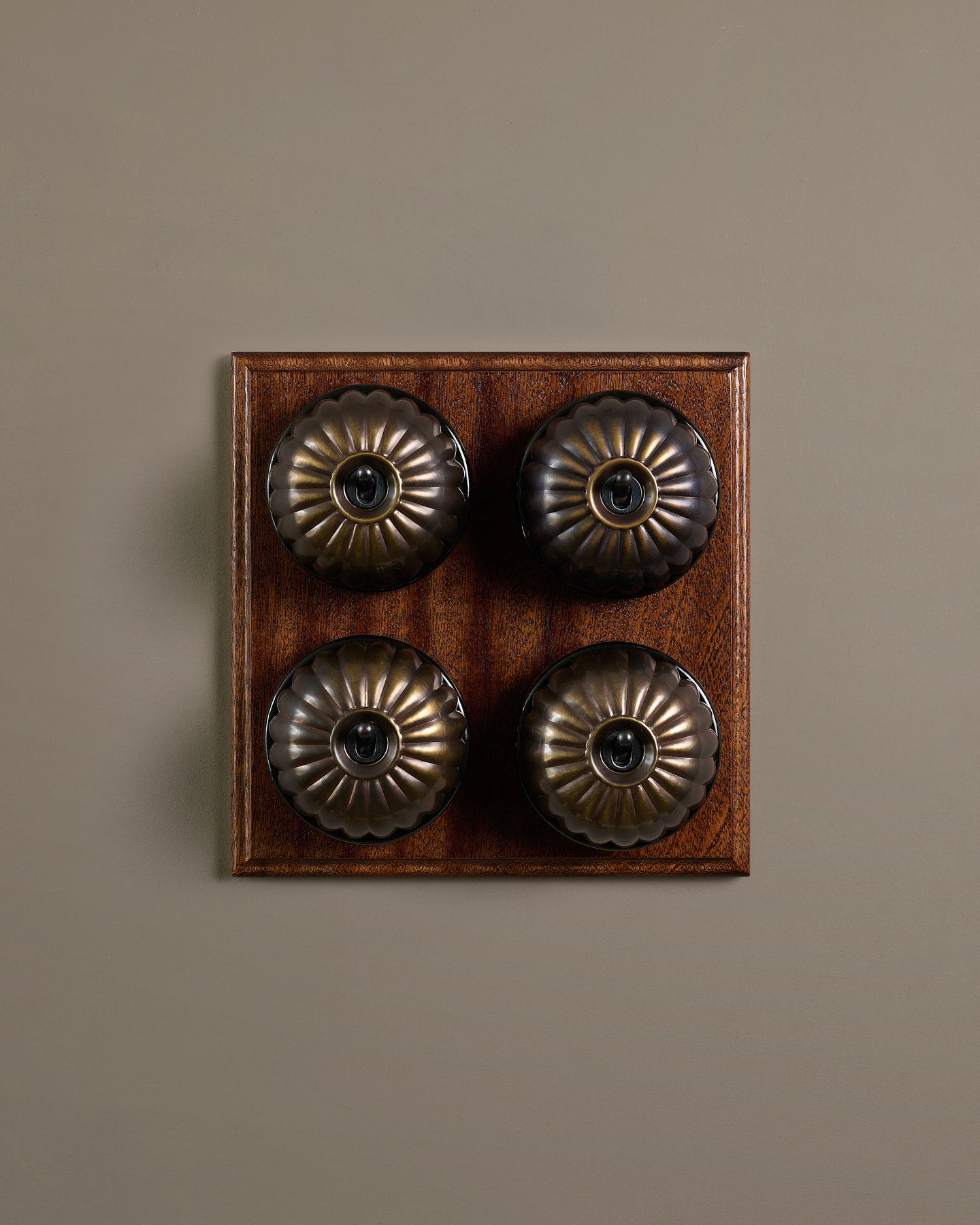 The Jelly Toggle Switch (4 Gang Bank & Mahogany Finish Pattress) - Oxidised Brass with Black Base.