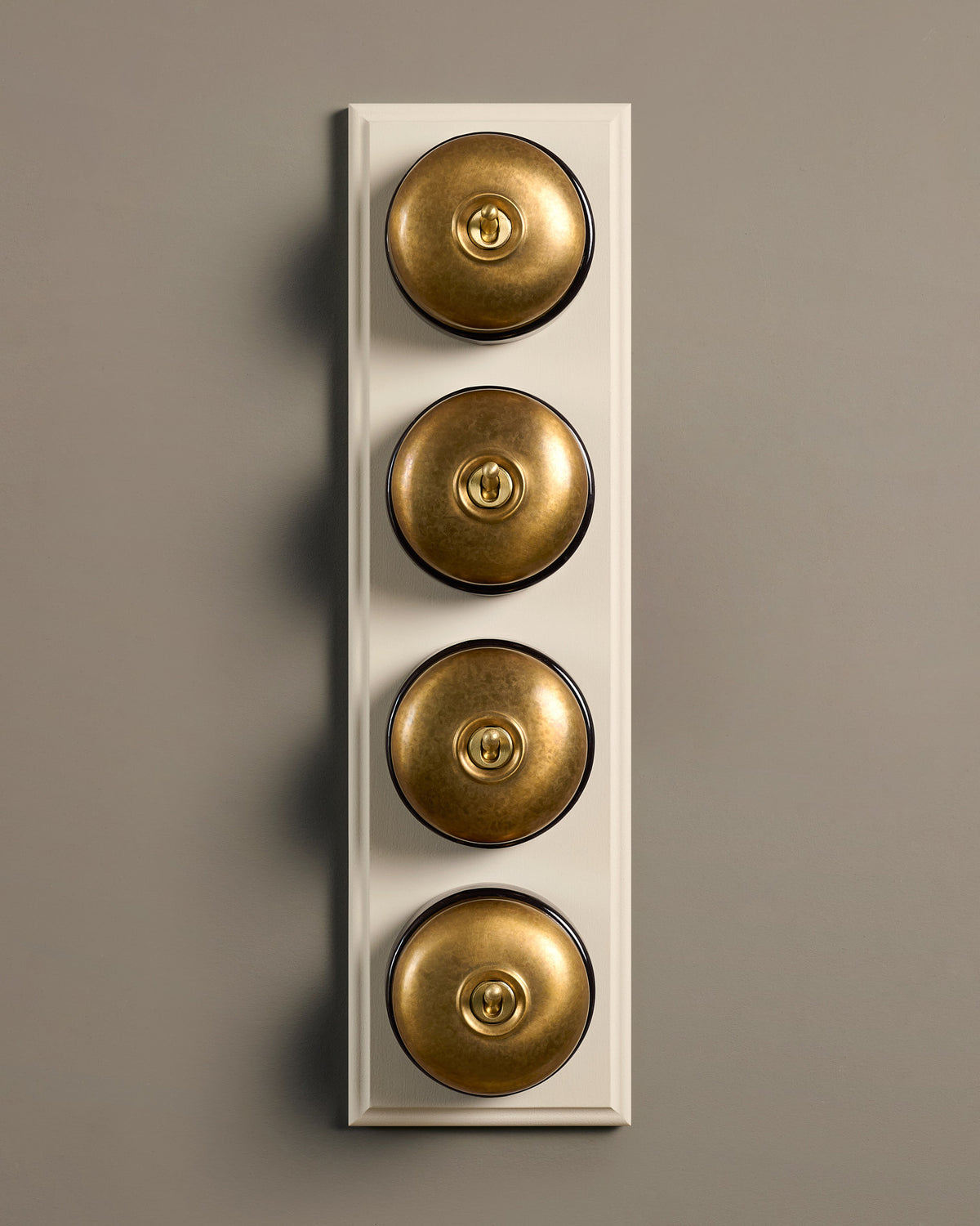 The Dolly Toggle Switch (4 Gang Row & Primed Maple Pattress) - Aged Brass with Black Base. TEST