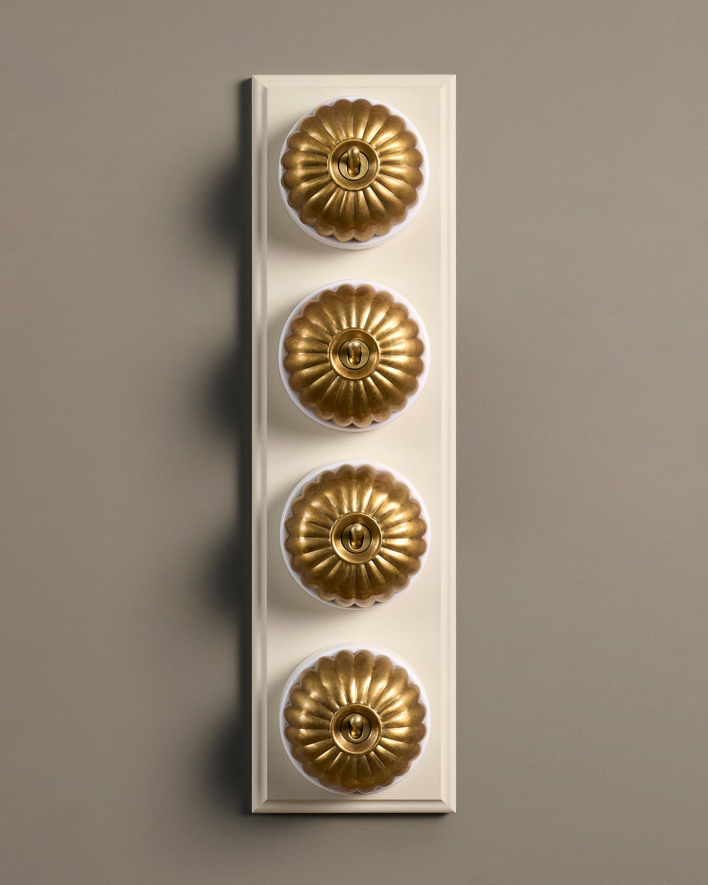 The Jelly Toggle Switch (4 Gang Row & Primed Maple Pattress) - Aged Brass with White Base.