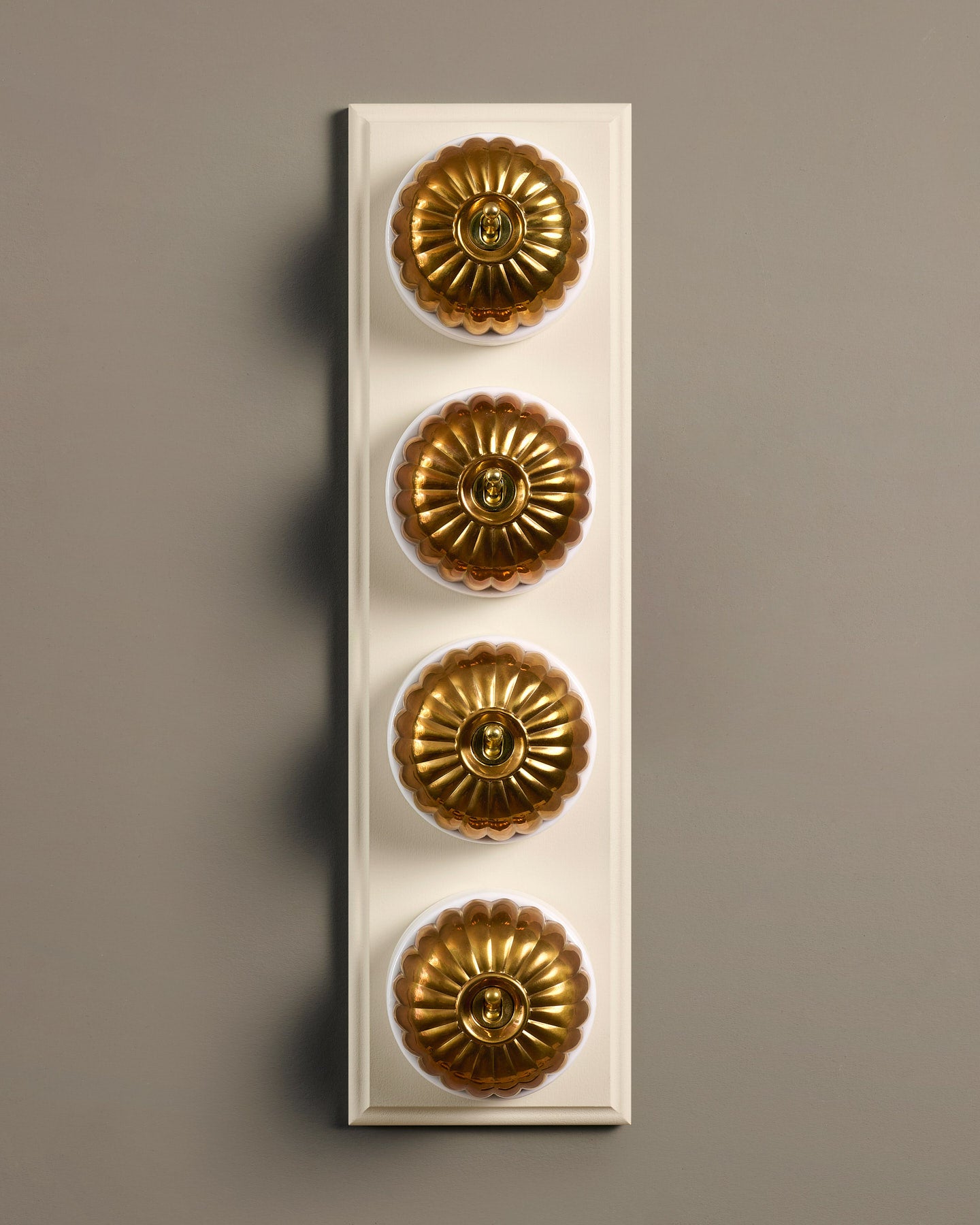 The Jelly Toggle Switch (4 Gang Row & Primed Maple Pattress) - Heirloom Brass with White Base.
