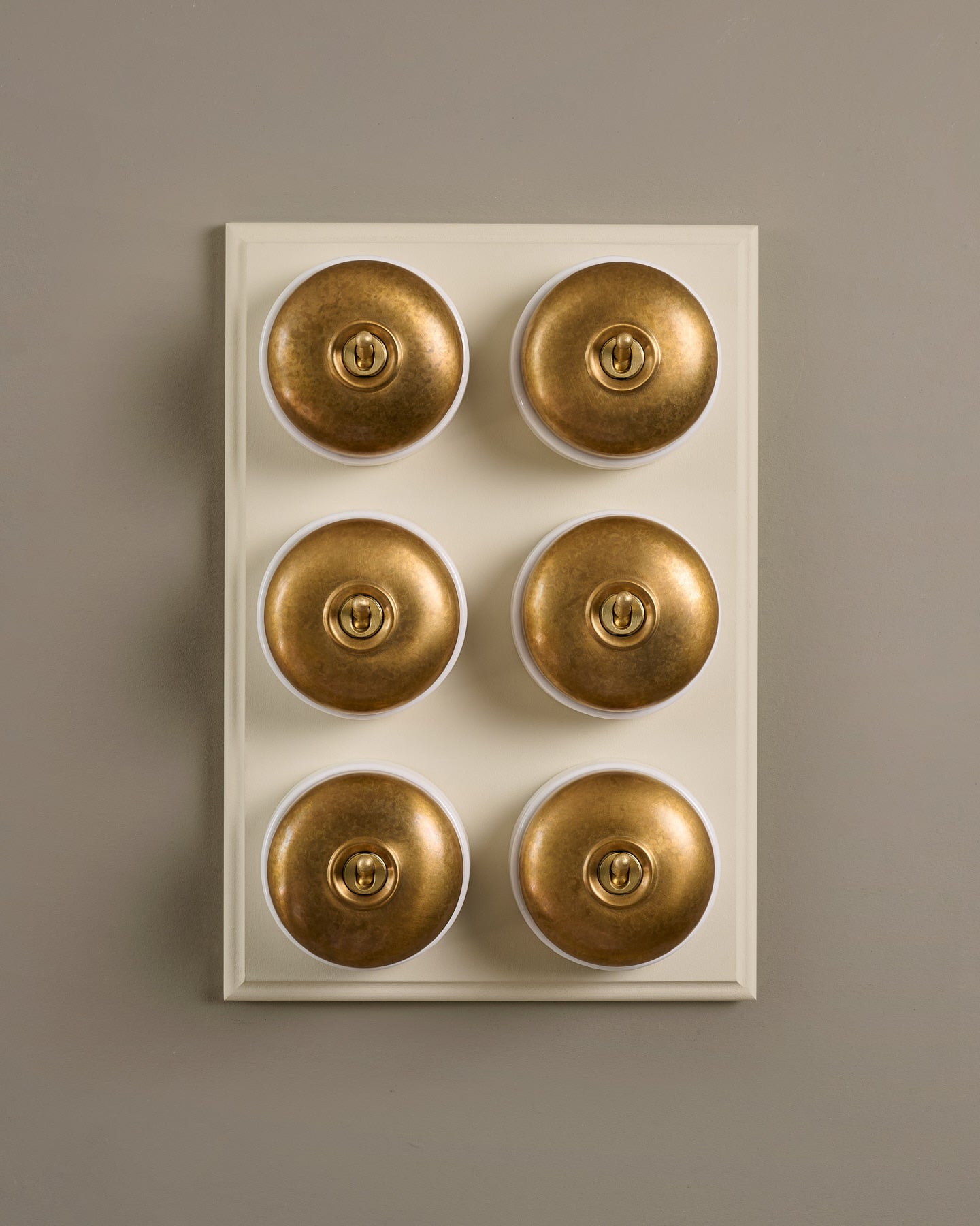 The Dolly Toggle Switch (6 Gang & Primed Maple Pattress) - Aged Brass with White Base.