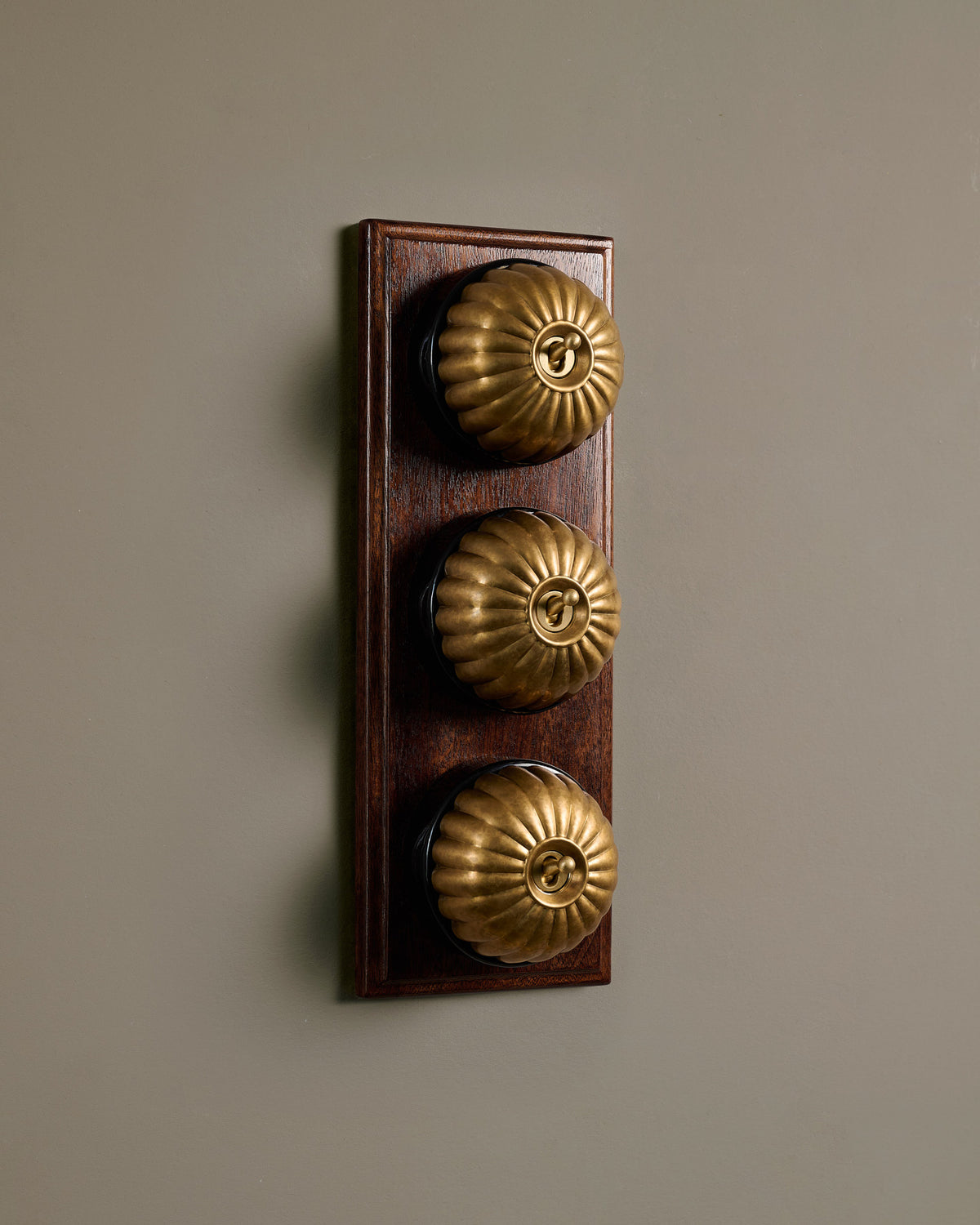 The Jelly Toggle Switch (3 Gang & Mahogany Finish Pattress) - Aged Brass with Black Base. TEST