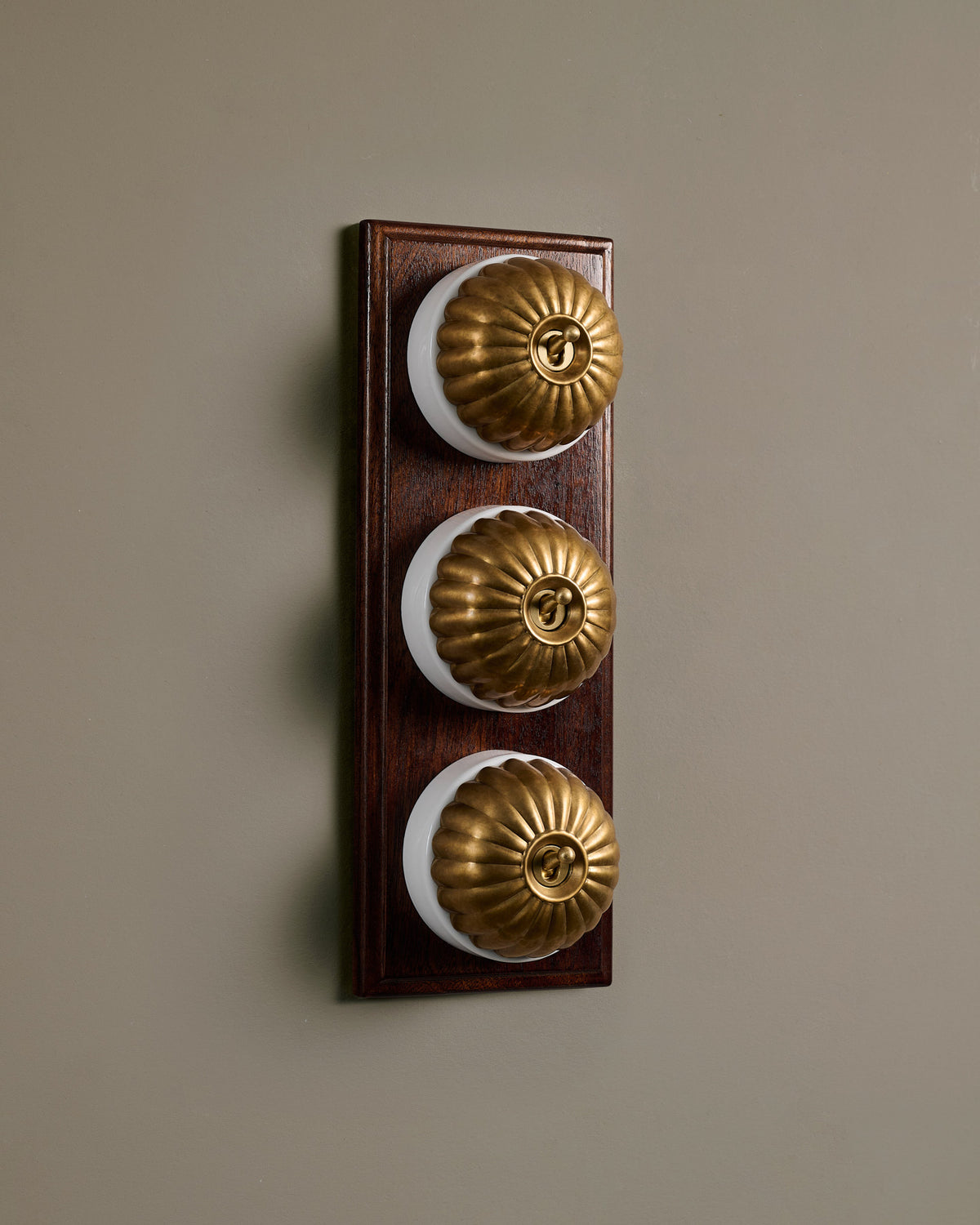 The Jelly Toggle Switch (3 Gang & Mahogany Finish Pattress) - Aged Brass with White Base. TEST