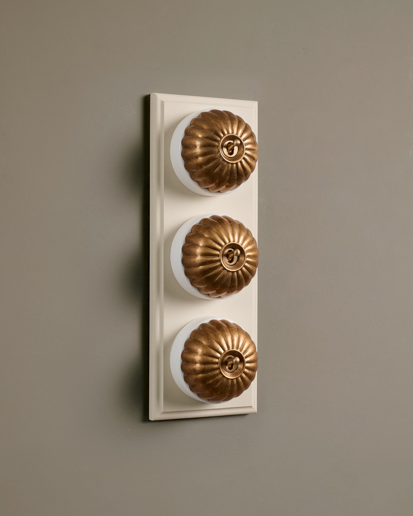 The Jelly Toggle Switch (3 Gang & Primed Maple Pattress) - Aged Brass with White Base.