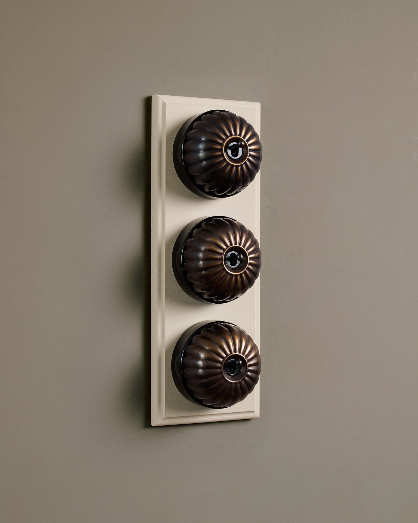 The Jelly Toggle Switch (3 Gang & Primed Maple Pattress) - Oxidised Brass with Black Base.