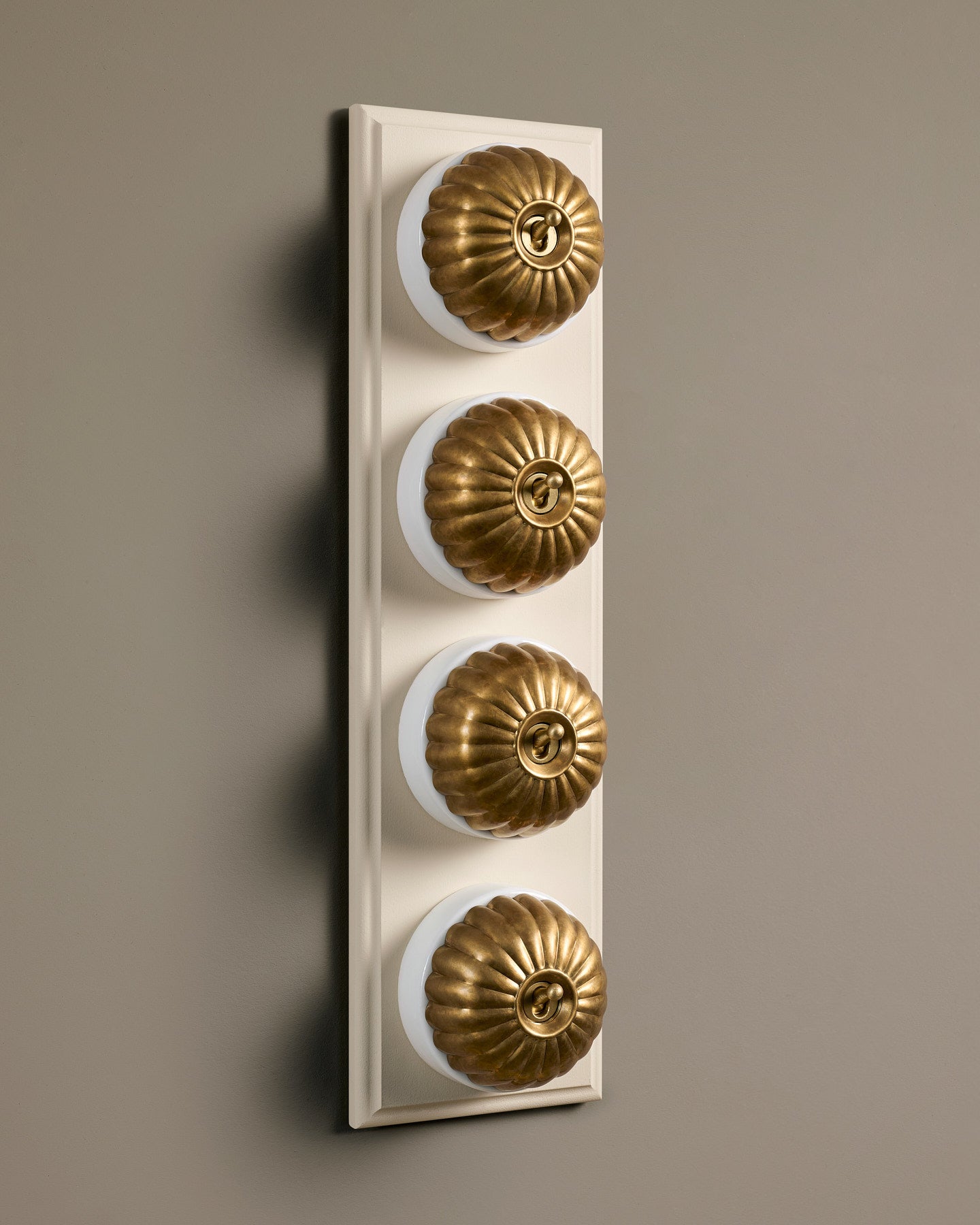 The Jelly Toggle Switch (4 Gang Row & Primed Maple Pattress) - Aged Brass with White Base.