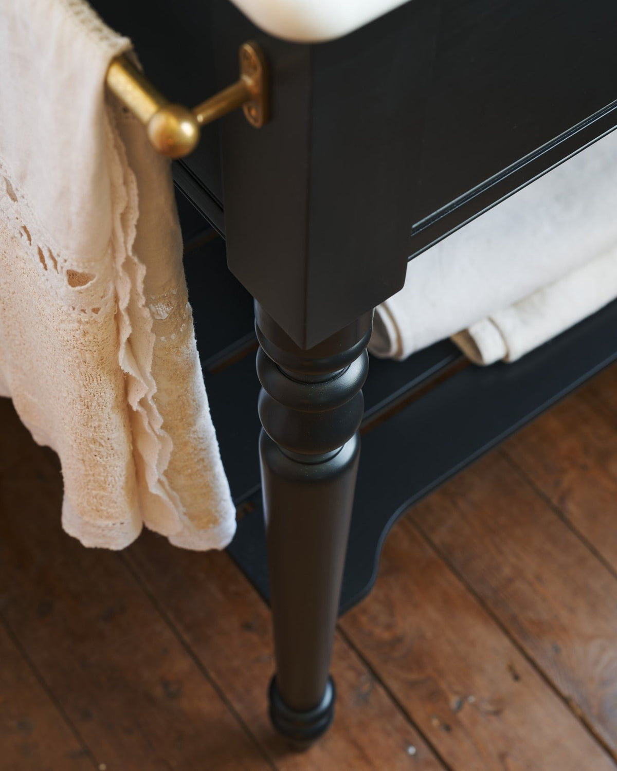A close-up oblique view of a pair of aged brass pillar taps with crosshead handles for a bathroom basin sink. TEST