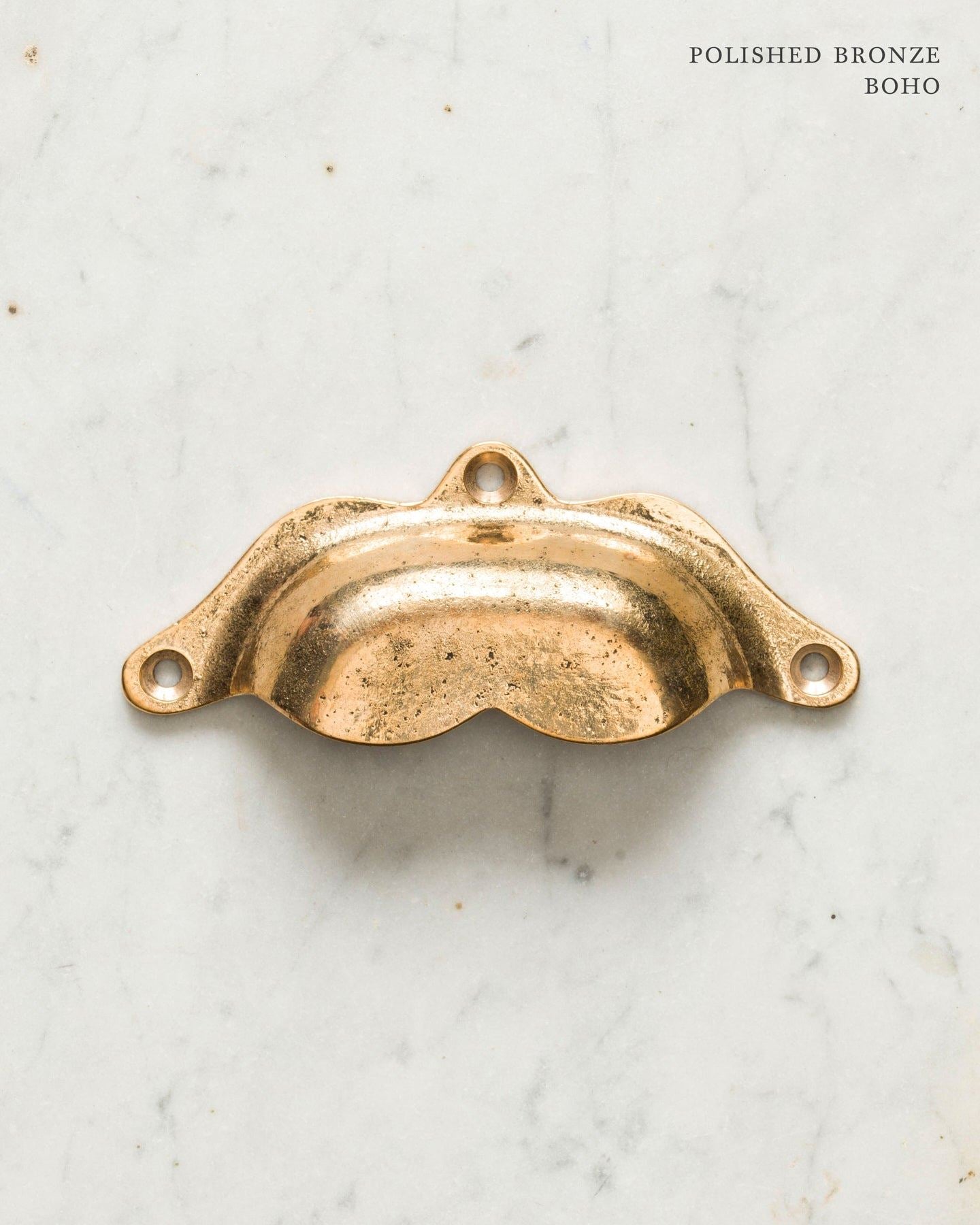 Two bohemian-style cup handles for a kitchen cupboard or drawer with a bright polished bronze finish. There is a large and a small size.
