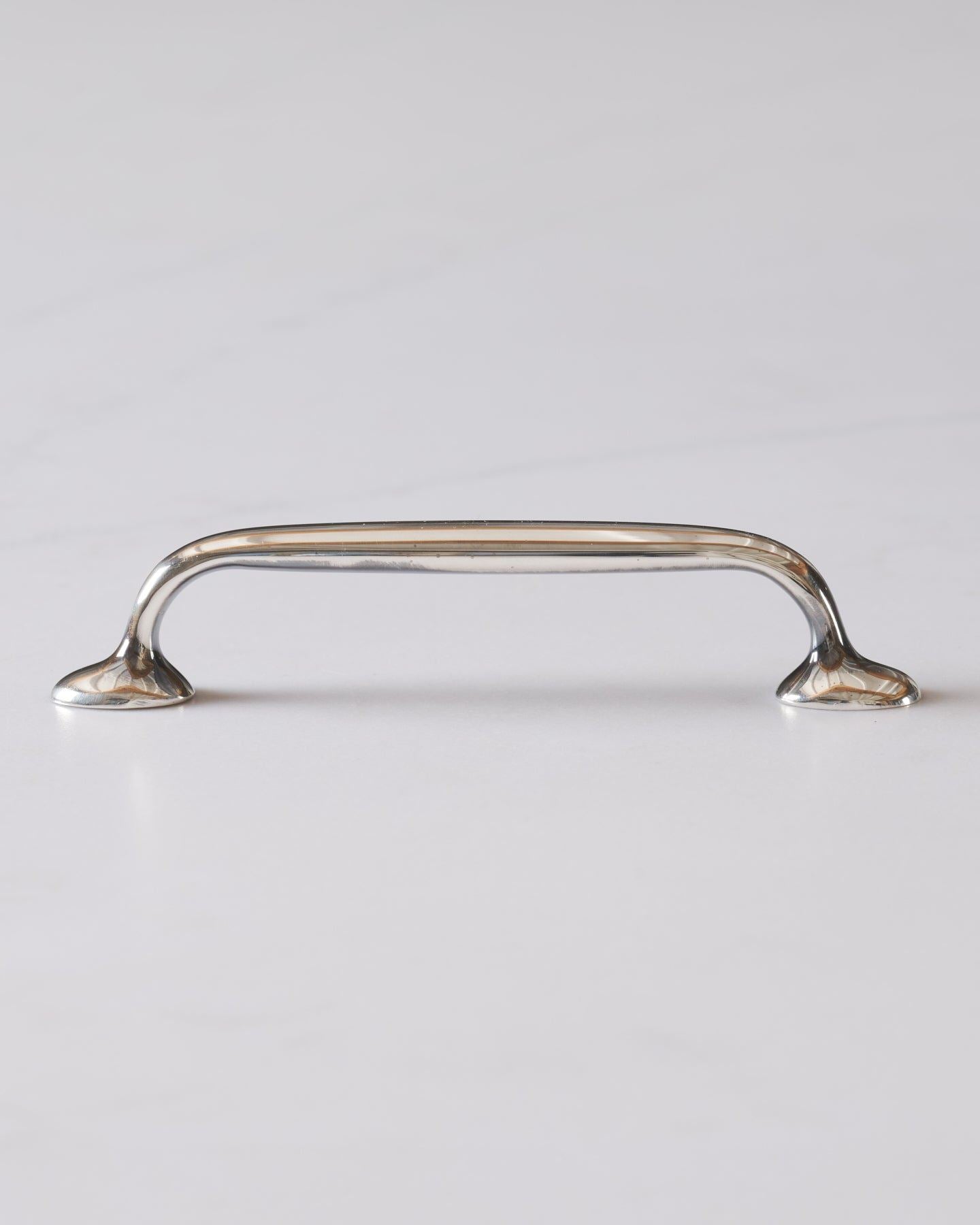 A profile view of a simple pull handle for a kitchen cupboard or drawer in a tarnished 'Bella' silver finish.