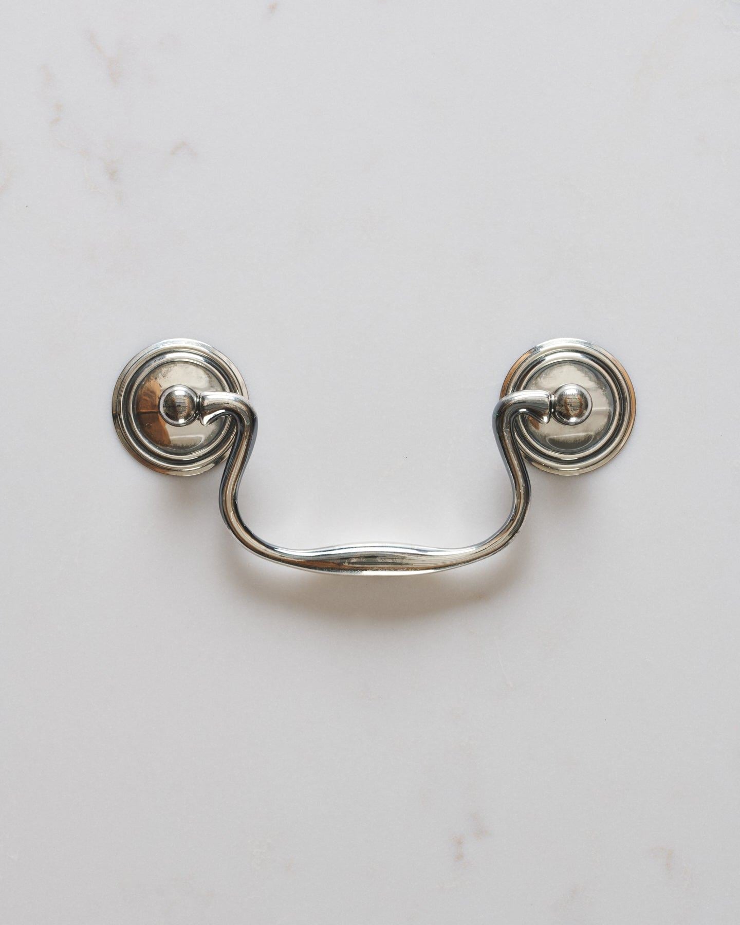A Georgian-style swing handle for a kitchen cupboard or drawer in a tarnished 'Bella' silver finish.