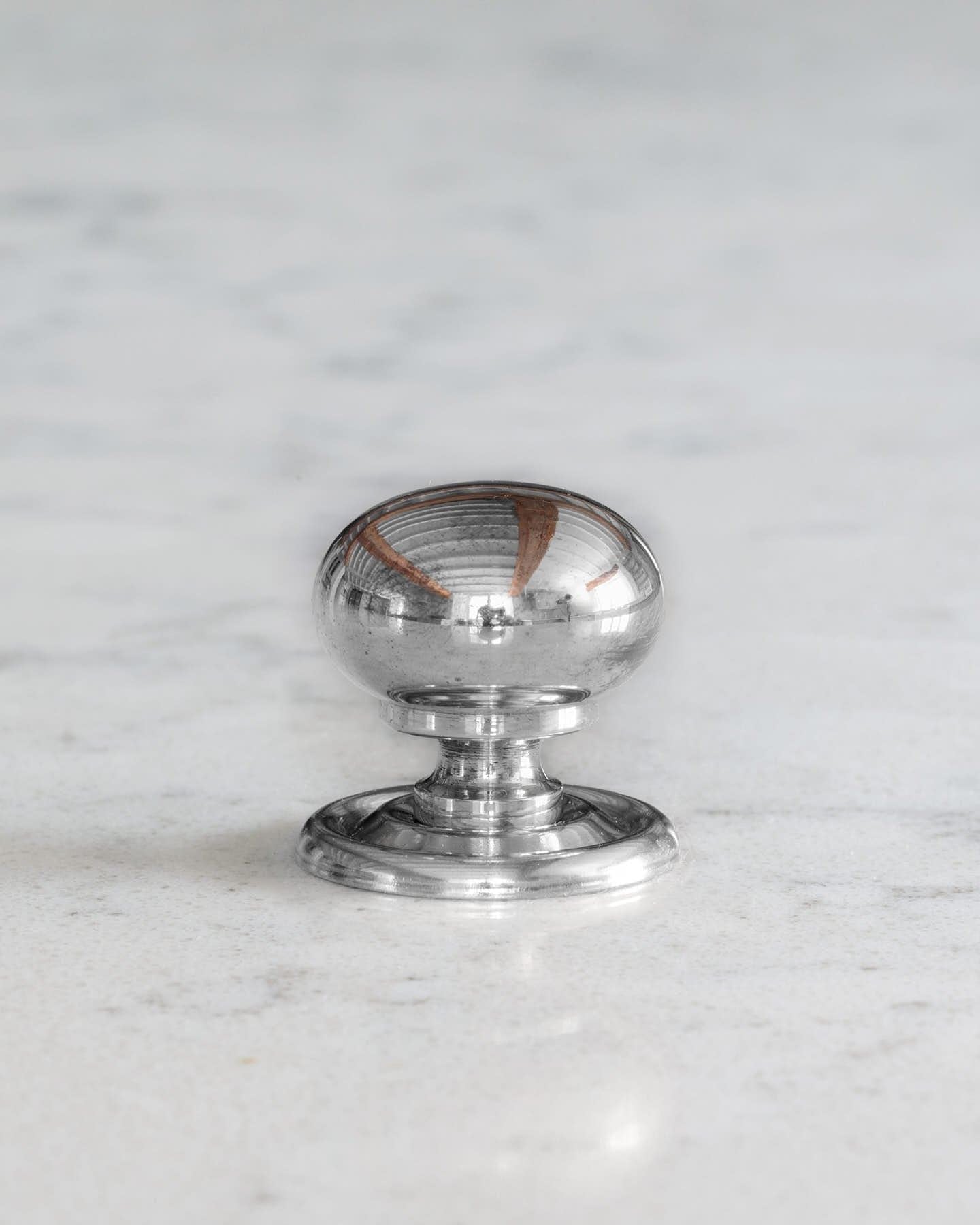 A 'Small' round doorknob with a pressed backplate for a kitchen cupboard or drawer in a polished chrome finish.