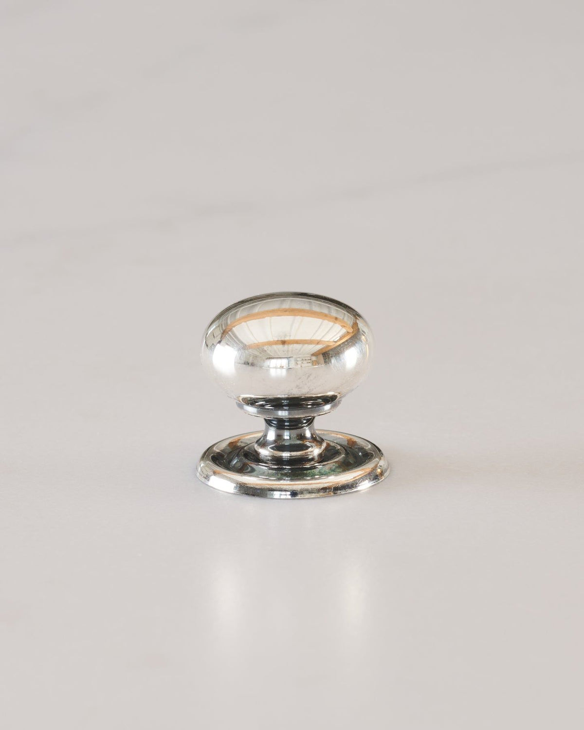 A 'Small' round doorknob with a pressed backplate for a kitchen cupboard or drawer in a tarnished silver finish. TEST