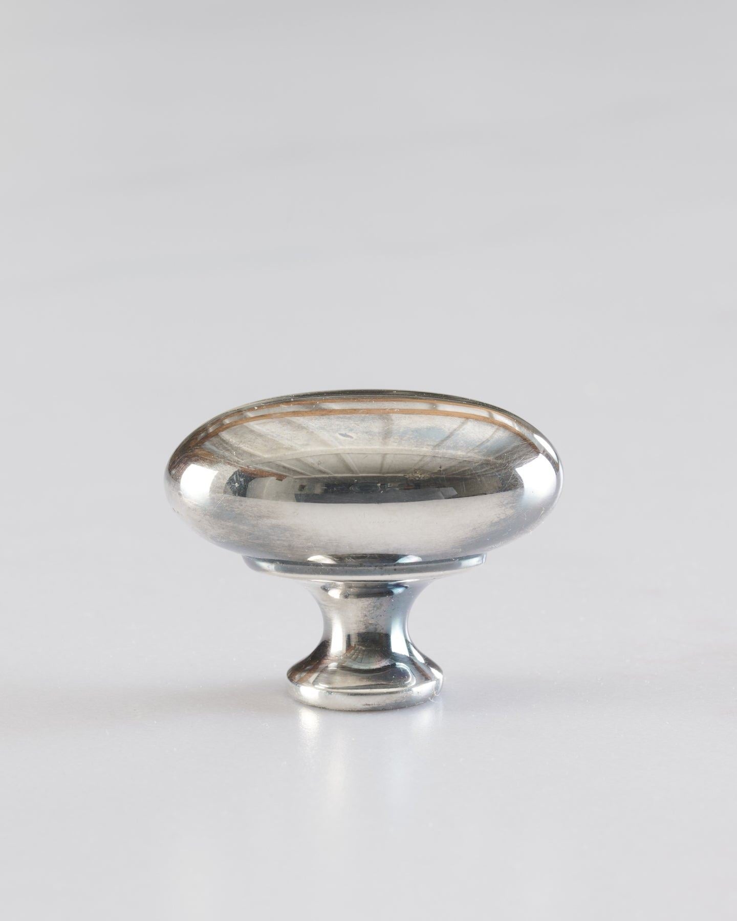 A 'Medium' oval-shaped knob for a kitchen cupboard or drawer with a tarnished silver finish.
