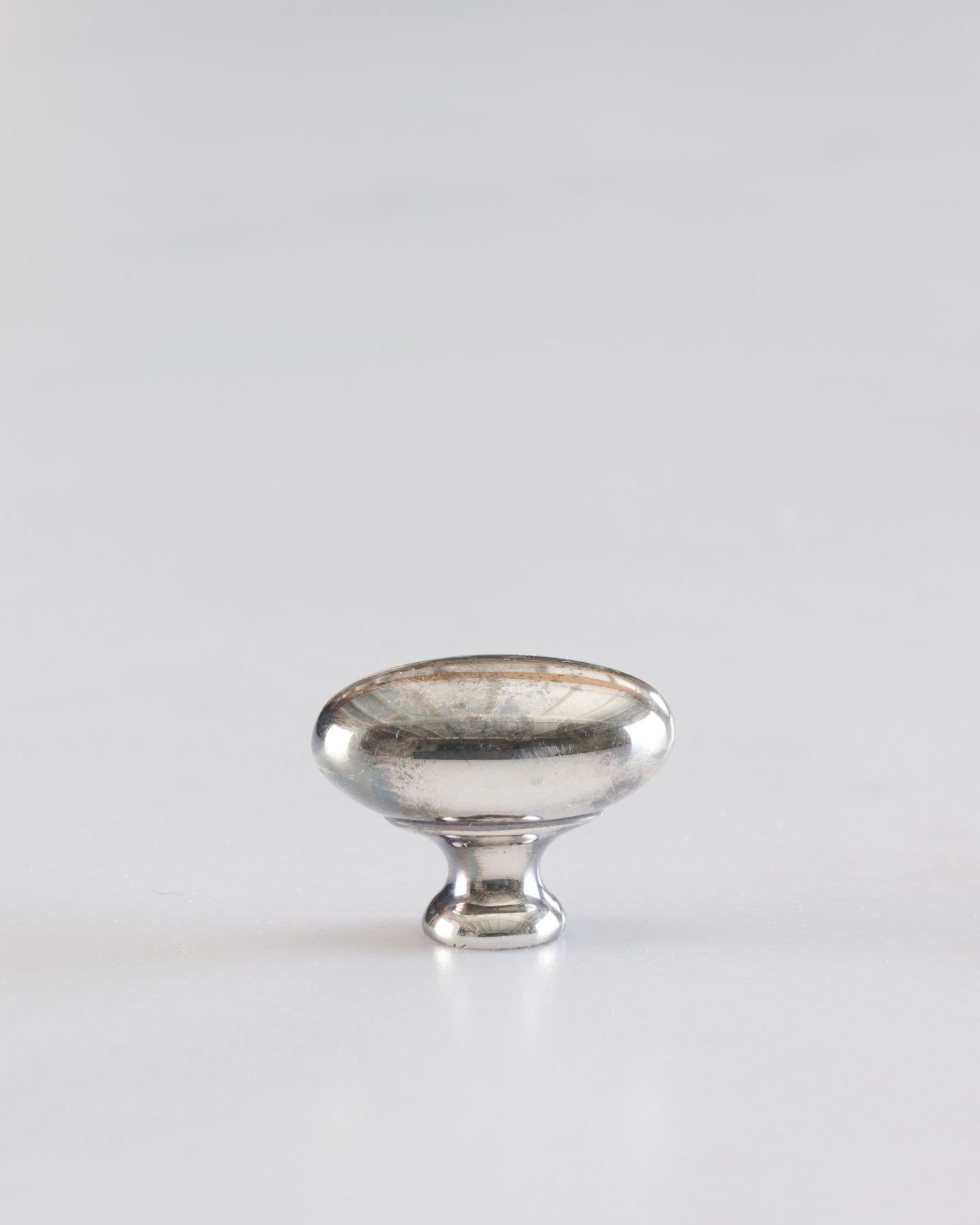 A 'Petite' oval-shaped knob for a kitchen cupboard or drawer with a tarnished silver finish.
