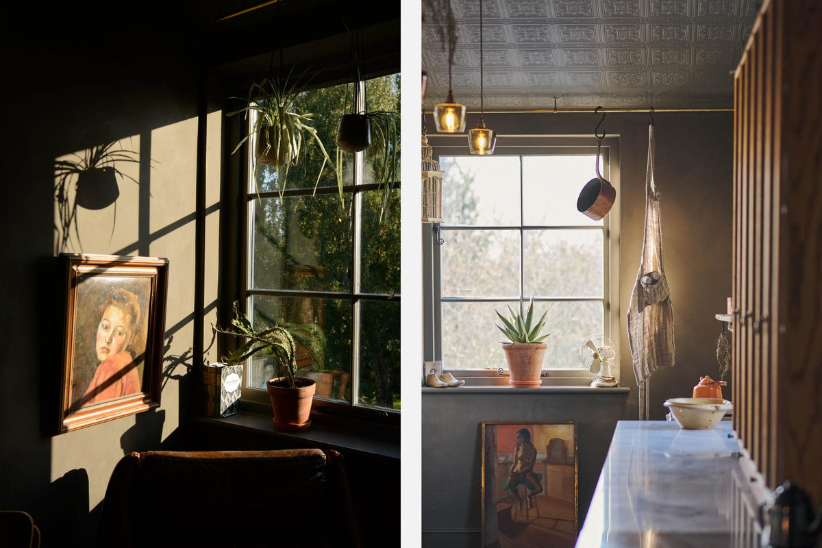 Nestled between a long sink run with a Carrara marble and copper worktop and countertop cupboards, the warm and inviting Haberdasher’s kitchen is adorned with luscious green hanging and potted plants, vintage items, artisan ceramics, illustrative tea towels, paintings, and a beloved white gas stove. This kitchen creates a lovely exhibitionist space that is both beautiful and practical.