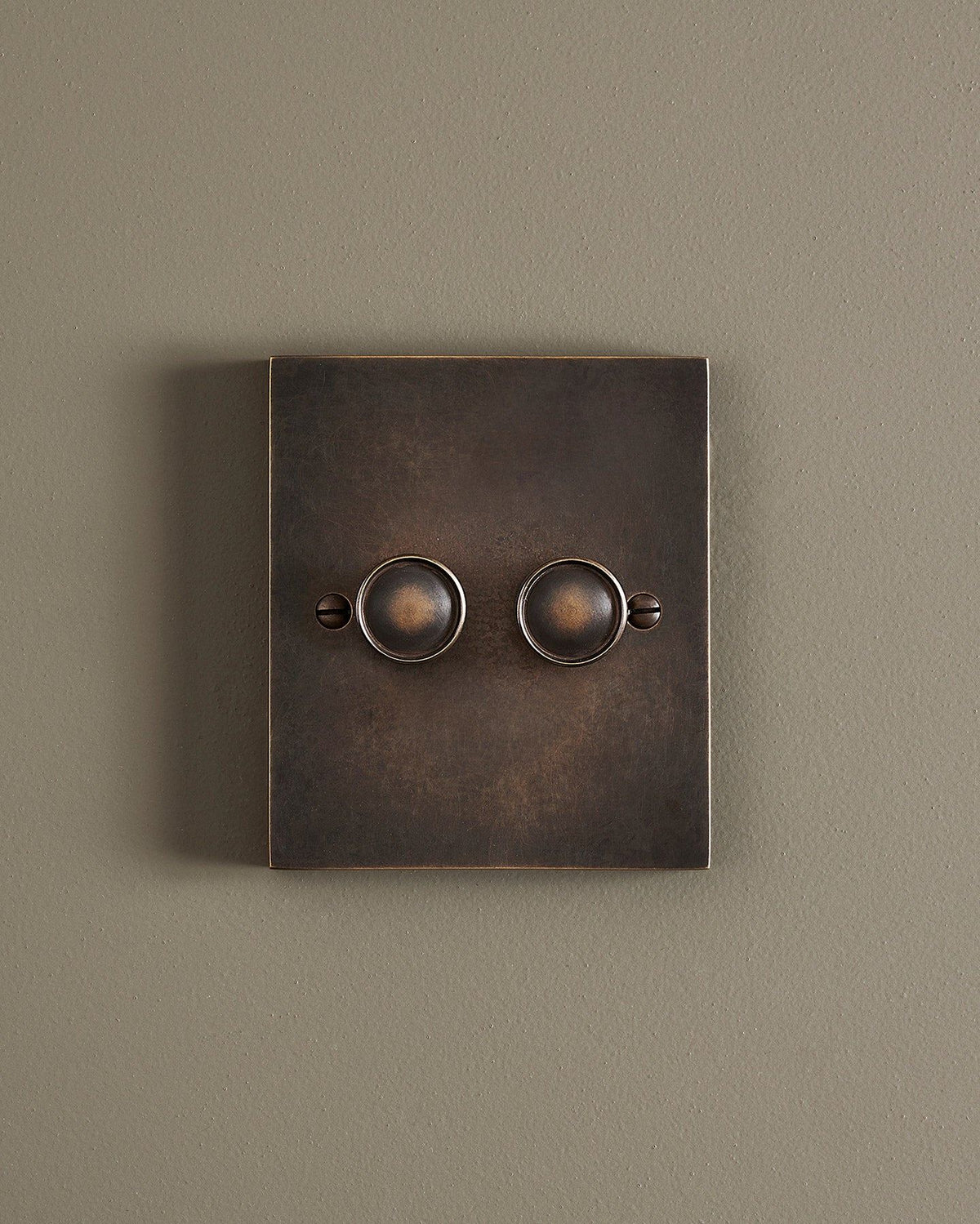 A straight-on view of a 2 gang box dimmer switch in a dark oxidised brass finish. TEST