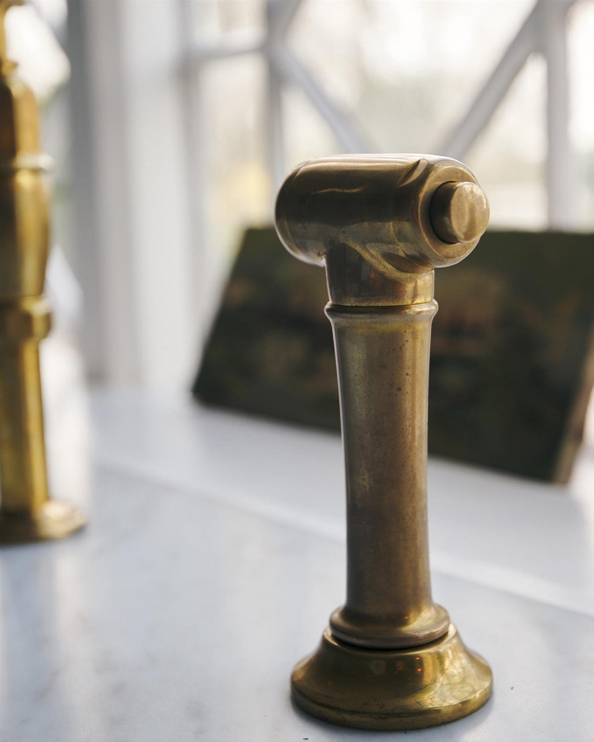 A close-up view of a traditional-style aged brass rinser tap. TEST