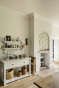 A small section of the renovated medieval house’s kitchen is a drinking station with a white linen prep table, a Silestone worktop, and shelves with a brass hanging rail. It is elegantly adorned with vintage furniture, artisan ceramics, mugs, and a collection of teas and coffee beans, seamlessly blending the historical with the contemporary.
