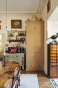 Next to the eccentric yet grand Bakehouse Green Classic English Kitchen features a butter yellow pantry cupboard. Pridefully displaying taxidermy, artisan ceramics, and collectable antiques, it embraces a unique museum-like social kitchen space.