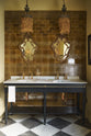 A beautiful butter-yellow powder room, you’ll find a black twin Victorian washstand, tall sepia lace market tiles, and a Parisian chequered marble floor. Paired with antique mirrors, pendant lights, vintage paintings, and framed pressed botanical artworks, the room exudes a glamorous, vintage charm.
