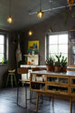 A quiet corner of a warm and inviting Haberdasher’s kitchen features a long sink run with a copper worktop, and glazed wall cupboards. Adorned with a luscious green potted plant, vintage items, artisan ceramics, and a golden framed floral painting, this kitchen creates a lovely exhibitionist space that is both beautiful and practical.