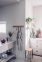 An angled corner of the humble Mushroom colour shaker kitchen with an all-in-one L-shaped sink and cooker run, and a small rolling kitchen island with Carrara marble worktop.