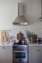A closer look at the silver gas stove with matching chimney cooker hood of the Mushroom colour shaker kitchen with Carrara marble worktop.