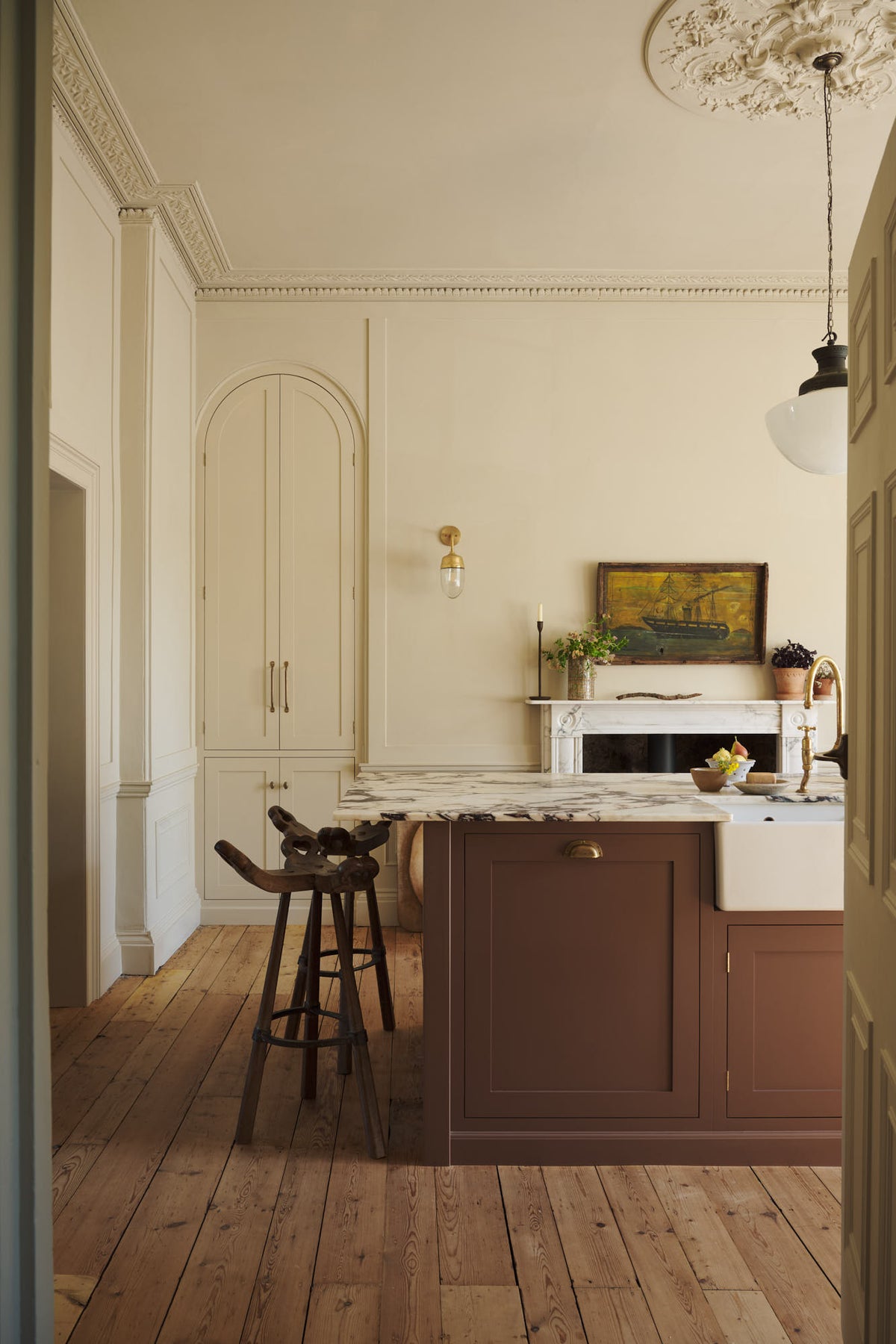 A bright, spacious, warm, and simple-yet-grand shaker kitchen featuring a large kitchen island with a Calacatta Viola worktop. Perfectly decorated with beloved vintage furniture and decor made from different natural materials, it creates a scene of absolute beauty, personality and functionality.