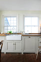 A closer look at the small and quaint mushroom-coloured Shaker kitchen’s features a sink run with a double Belfast sink, stave hardwood worktop, and an antique silver Ionian tap. Beautifully decorated with vintage furniture such as a large solid oak table, a silver scale, and assorted bric-a-brac, it creates a lovely social space full of character.