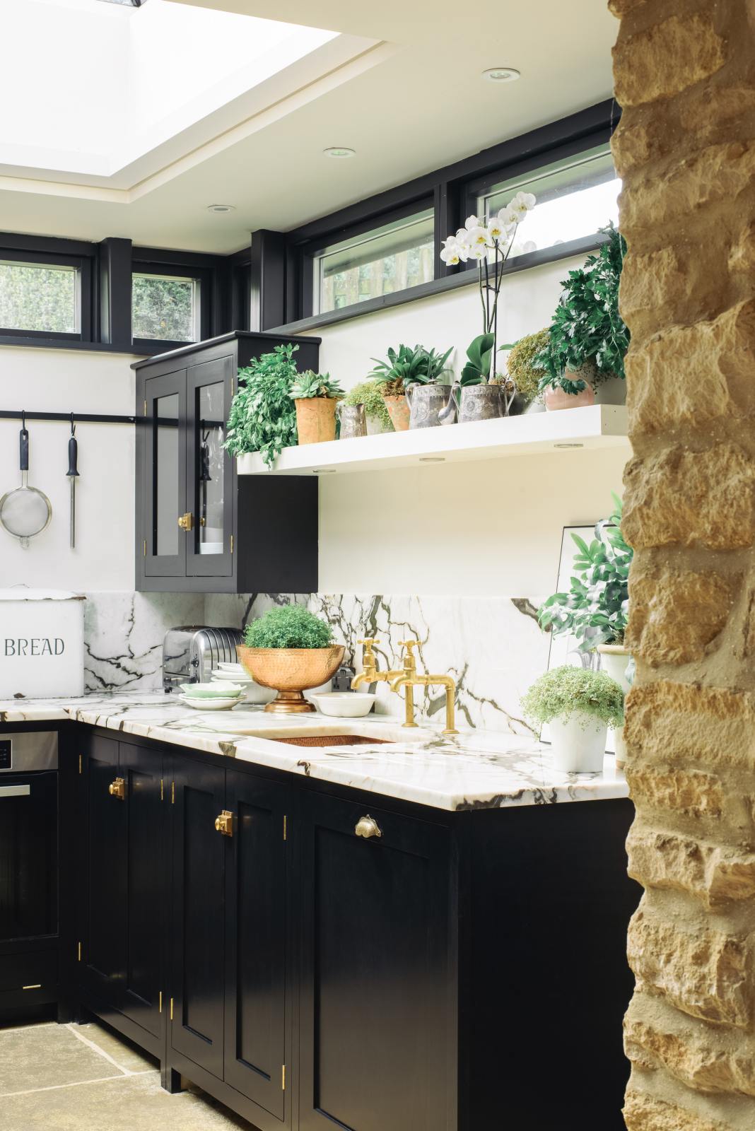 A closer look at the Painter’s Black shake kitchen’s single copper sink with aged brass Mayan taps and a San Simone quartzite worktop and splashback.