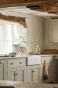 A closer look at the single Belfast sink with an antique silver Ionian tap in a simple English farmhouse style kitchen situated in deVOL’s headquarters at Cotes Mill, with low, exposed wooden beams and worn wooden floorboards. The walls are textured and wobbly and painted in a light, off-white shade.