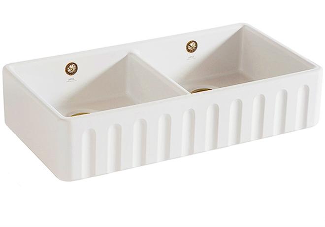 A cut-out image of a traditional fluted white ceramic Belfast sink with two basins.