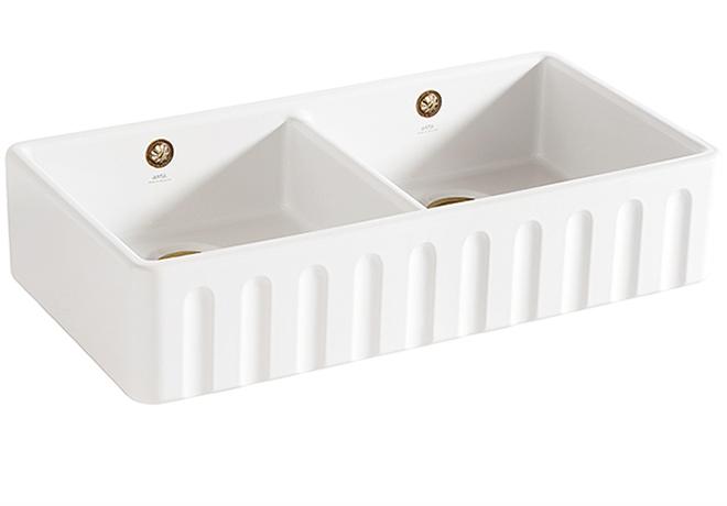 A cut-out image of a traditional fluted white ceramic Belfast sink with two basins.