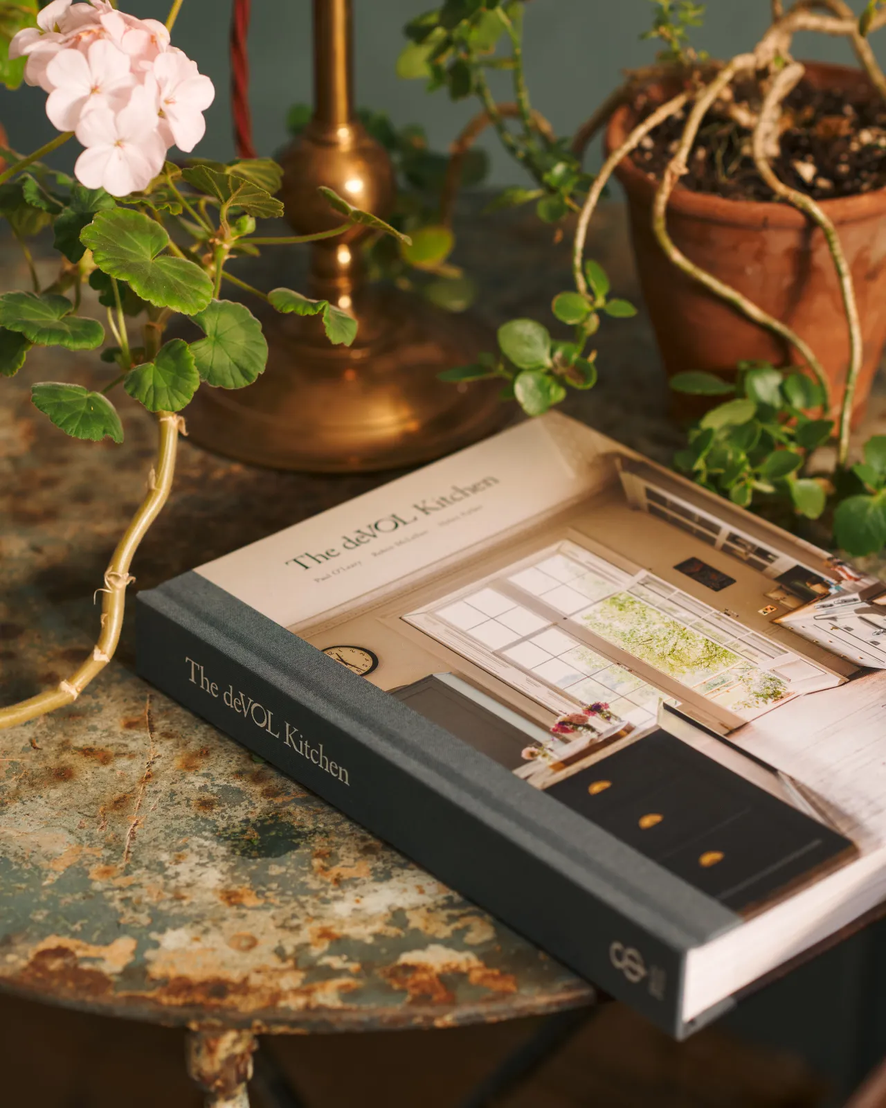 the deVOL book on a table next to a potted plant.