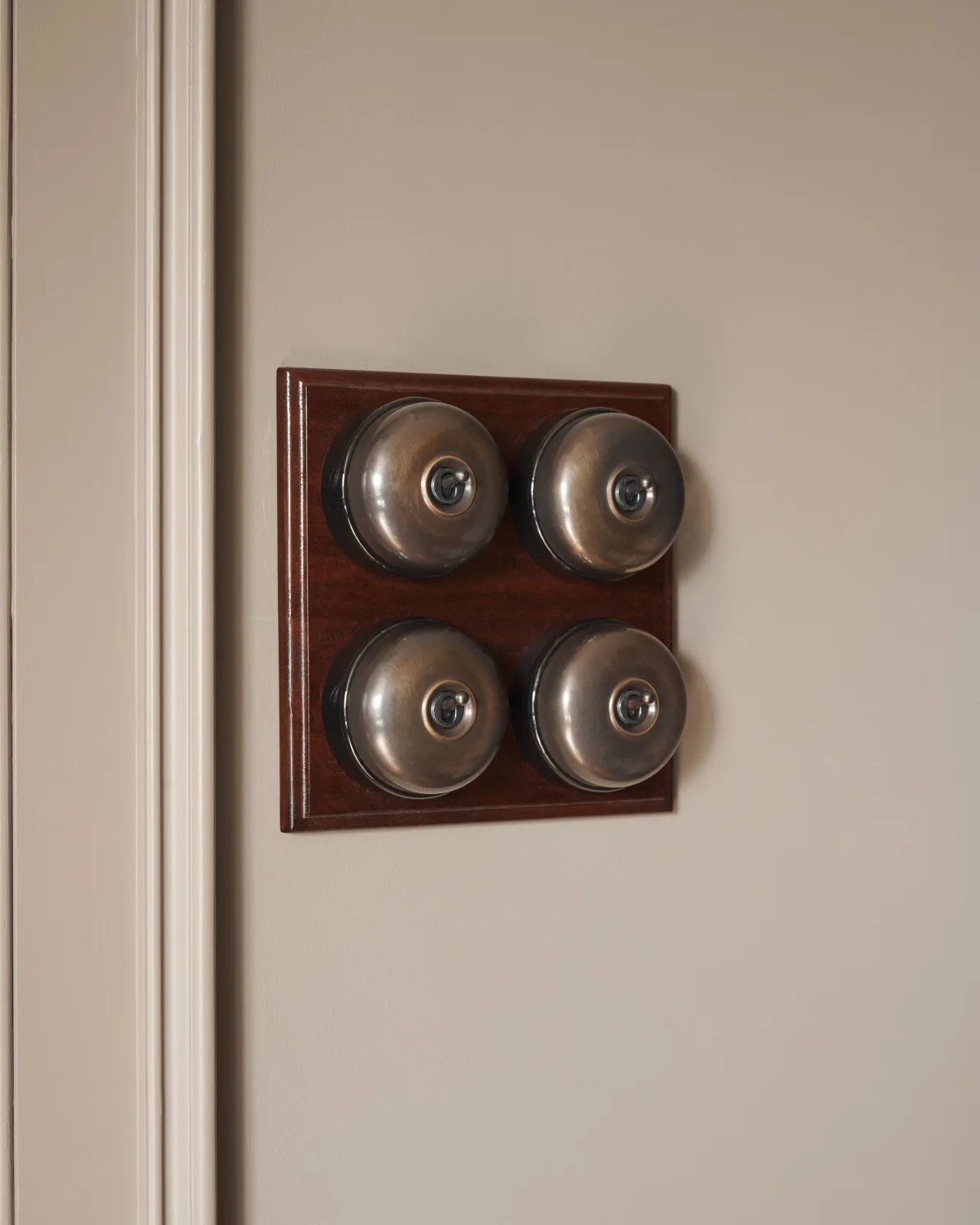 Four Oxidised Brass deVOL Dolly Toggle Switches fitted to a square shaped, polished Sapele pattress.