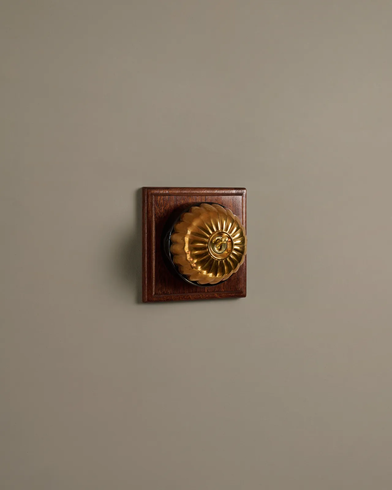 A deVOL Heirloom Brass Jelly Toggle Switches fitted to a Mahogany Finish pattress.