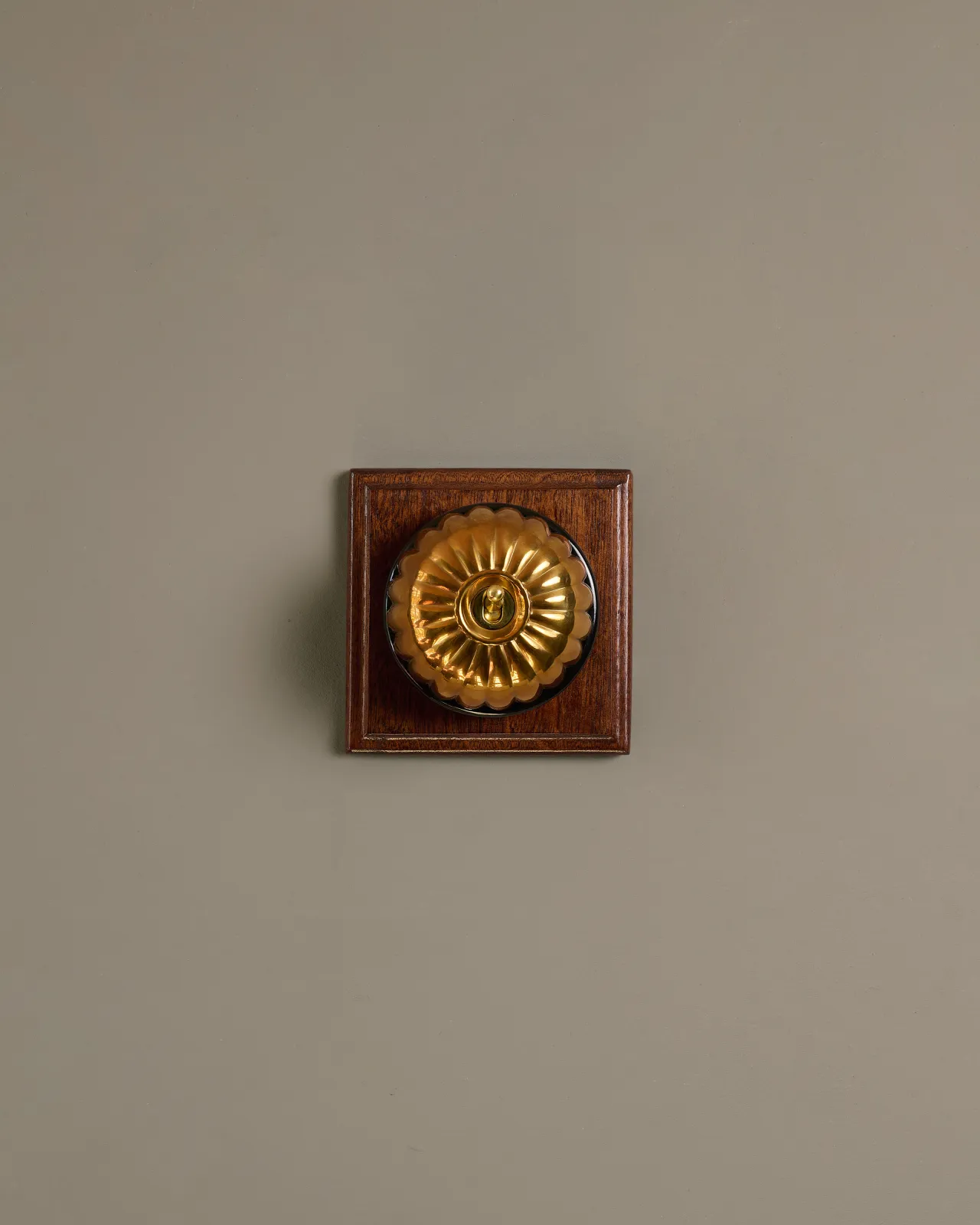 A deVOL Heirloom Brass Jelly Toggle Switches fitted to a Mahogany Finish pattress.