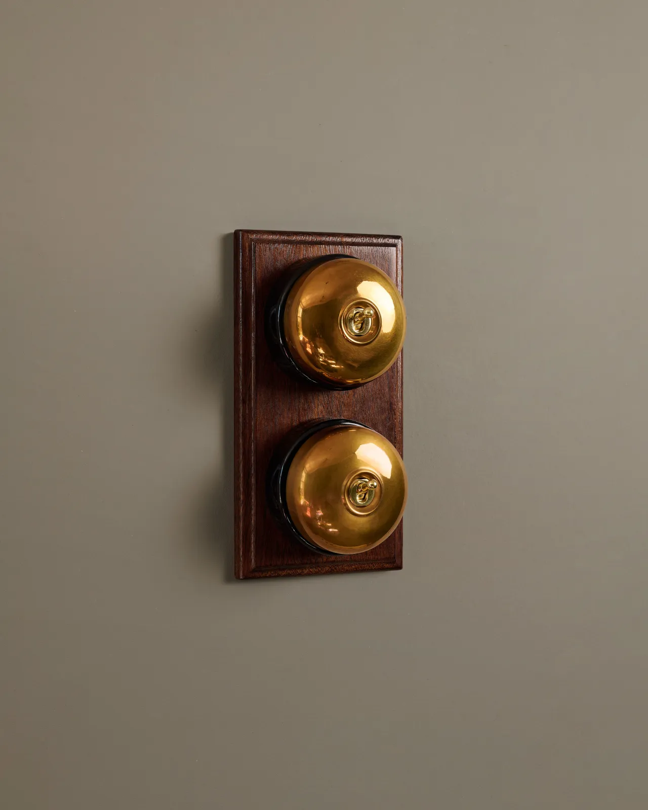 A pair of deVOL Dolly Toggle Switches fitted to a stained Sapele pattress.