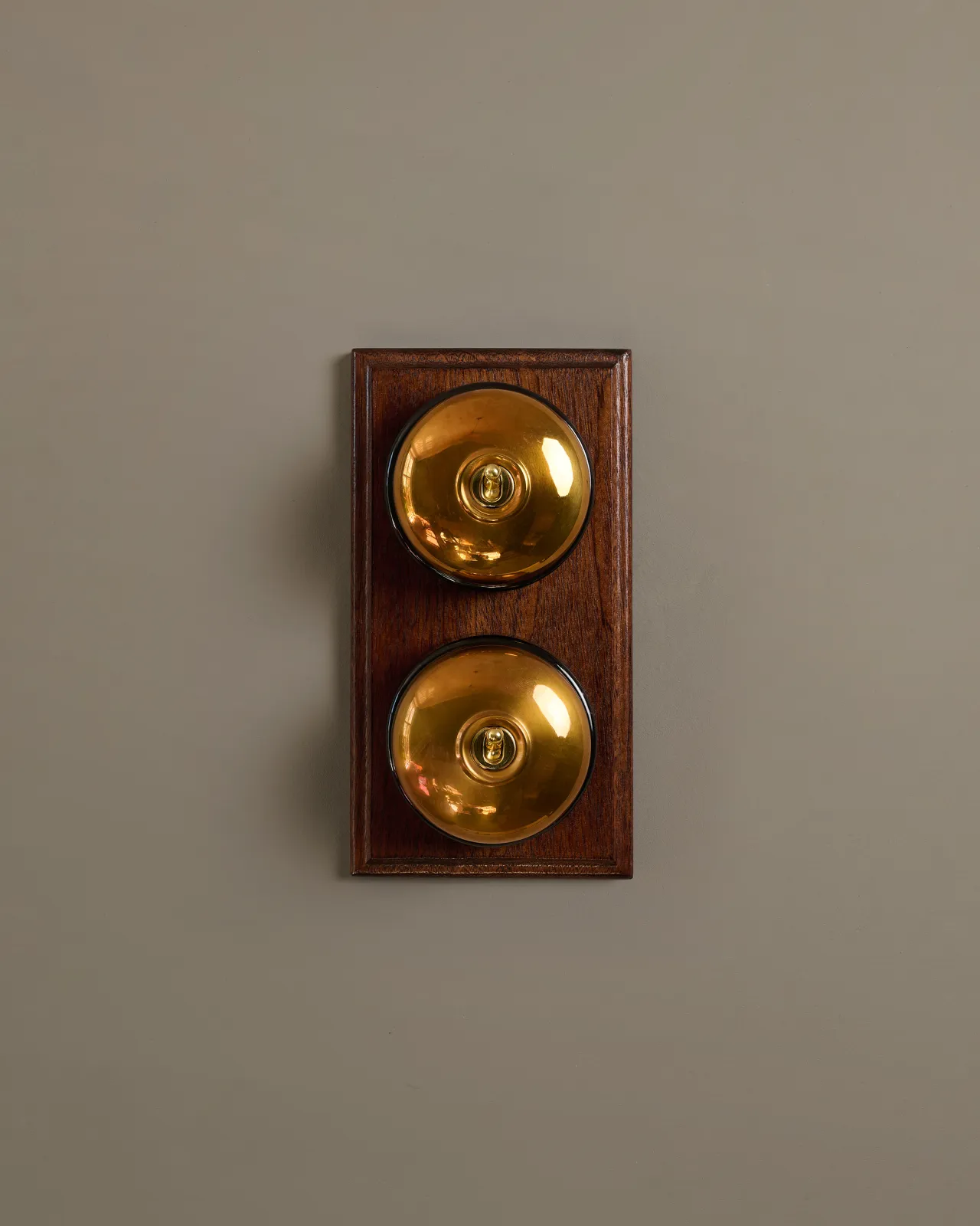 A pair of deVOL Dolly Toggle Switches fitted to a stained Sapele pattress.